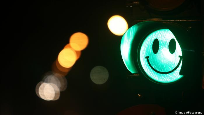 Un semáforo en verde con una cara feliz.