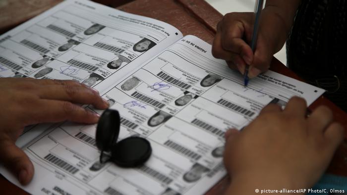 Foto simbólica de una persona que firma en un padrón electoral en Perú.