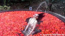 A participant, surrounded by red chilli peppers, takes part in a chilli-eating competition at a hot spring in Yichun, Jiangxi province, China December 9, 2018. Chen Fei/CNS via REUTERS ATTENTION EDITORS - THIS IMAGE WAS PROVIDED BY A THIRD PARTY. CHINA OUT. 