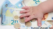 28.11.18, Symbolbild Geld, Kinderhand greift nach Stapel von 2 Euro Muenzen auf Geldscheinen | Verwendung weltweit