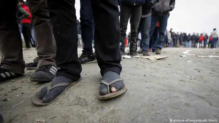 The feet of people waiting to cross into Croatia
