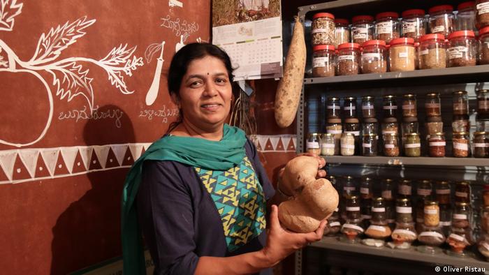 Anita Reddy, del banco de semillas Sahaja Organics, de India, frente a una estantería llena de frascos con semillas.