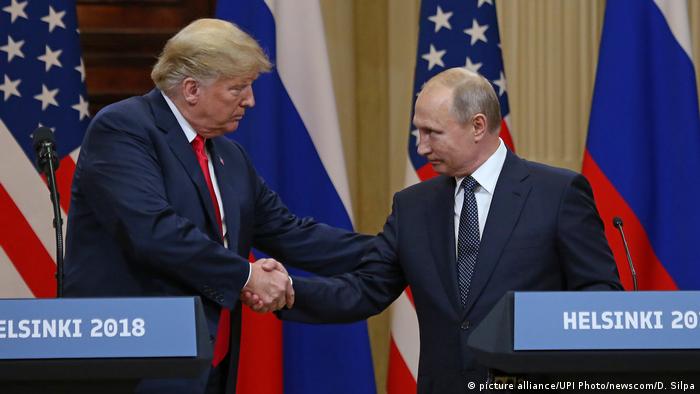 President Trump and President Putin shake hands behind two podiums