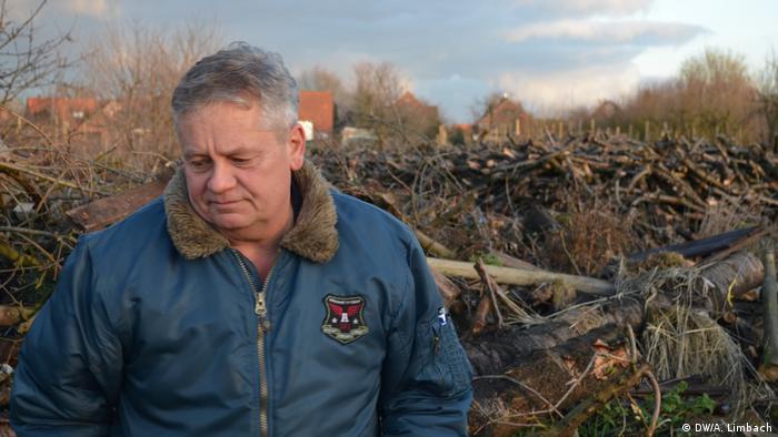 Biobauer Claus Blohm steht vor den gerodeten Überreste seiner Kirschbäume (Bild: DW/A. Limbach)