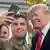 Soldier taking photo with Trump