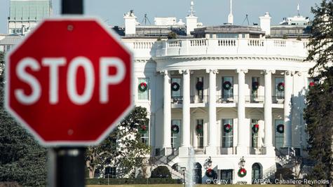 Casa Branca em Washington, com letreiro "Stop" em primeiro plano