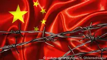 Stacheldraht mit Schatten vor einer chinesischen Flagge | Verwendung weltweit