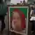 A Bangladeshi man walks past a portrait of Bangladesh Prime Minister Sheikh Hasina put up for sale at a roadside shop ahead of the general elections in Dhaka.