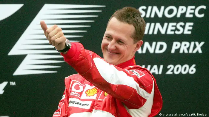 Michael Schumacher extiende el brazo levantando el pulgar.