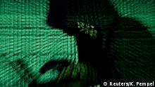 FILE PHOTO: A man holds a laptop computer as cyber code is projected on him in this illustration picture taken on May 13, 2017. Capitalizing on spying tools believed to have been developed by the U.S. National Security Agency, hackers staged a cyber assault with a self-spreading malware that has infected tens of thousands of computers in nearly 100 countries. REUTERS/Kacper Pempel/Illustration/File Photo