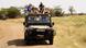 An open-topped Land Rover with tourists in the Serengeti National Park An open-topped Land Rover with tourists in the Serengeti National Park