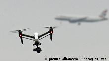 FILE - In this Feb. 25, 2017 file photo, a drone flies in Hanworth Park in west London, as a British Airways 747 plane in the background prepares to land at Heathrow Airport. British officials announced plans Saturday, July 22, 2017 to further regulate drone use in a bid to prevent accidents and threats to commercial aviation. (John Stillwell/PA via AP, File) |