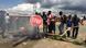 Protesters gather in a street in Harare, burning wood and holding a Stop sign Protesters gather in a street in Harare, burning wood and holding a Stop sign