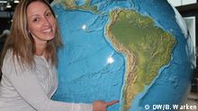 Die Deutschlehrerin Maddy deutet an einem Globus mit dem Finger auf Patagonien (DW/B. Warken)