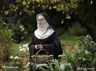 Frau mit Nonnenkostüm im Kräutergarten