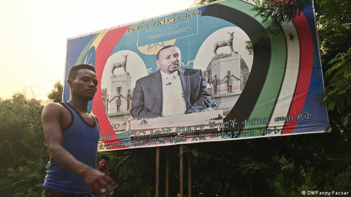 A man walks past a billboard of President Abiy Ahmed in Gambela, Ethiopia