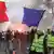 A man wearing a yellow vest waves a French flag at a protest in Paris