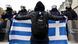 A protester holds up a Greek flag in front of police officers in Athens, Greece A protester holds up a Greek flag in front of police officers in Athens, Greece