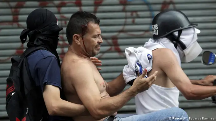 Un manifestante en Caracas es llevado en motocicleta a un lugar seguro. 