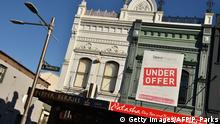 An under offer sign on a real estate board on a commercial property is seen in Sydney on August 1, 2017.
Australia's central bank held interest rates at a record low on August 1, as it warned that a strengthening local currency was hurting activity in an already soft domestic economy. / AFP PHOTO / PETER PARKS (Photo credit should read PETER PARKS/AFP/Getty Images)