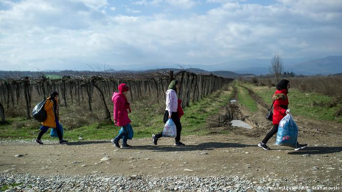 Migrants cross the border from North Macedonia to Greece