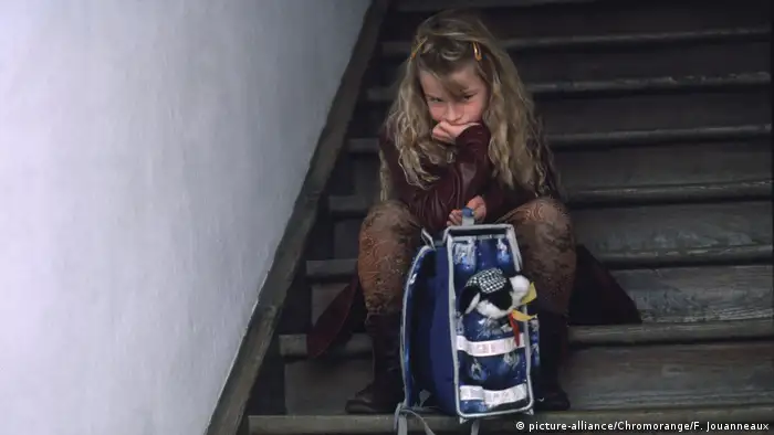 Ein Mädchen mit Schulranzen sitzt im Treppenhaus (picture-alliance/Chromorange/F. Jouanneaux)
