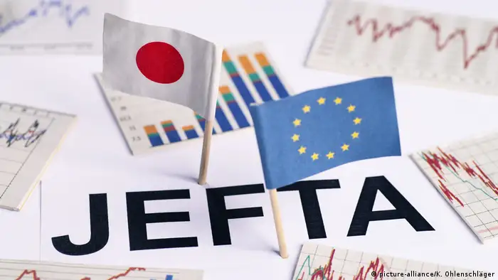 EU-Japan free trade deal symbolized by miniature EU and Japanese flags surrounded by bar charts and graphs