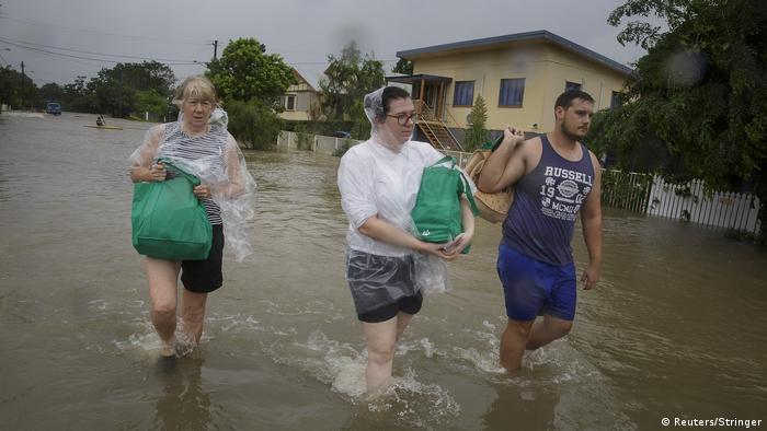 Residents of Townsville walk through floodwater