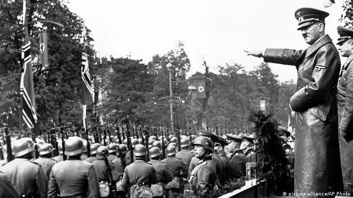 Adolf Hitler nimmt mit gestreckten Arm eine Parade ab (picture-alliance/AP Photo)