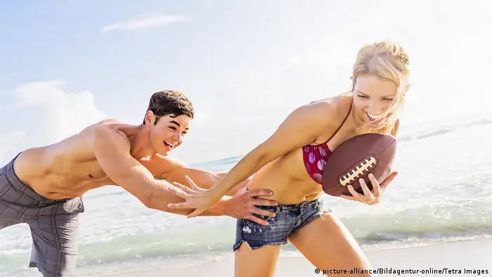 Paar spielt am Strand mit Football (picture-alliance/Bildagentur-online/Tetra Images)
