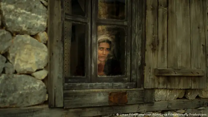 Filmszene aus A Tale of Three Sisters zeigt eine Frau aus dem Fenster einer einfachen Hütte blickend (Liman Film/Komplizen Film/Circe Films/Horsefly Productions)