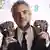 Alfonso Cuaron holds up his BAFTA statues