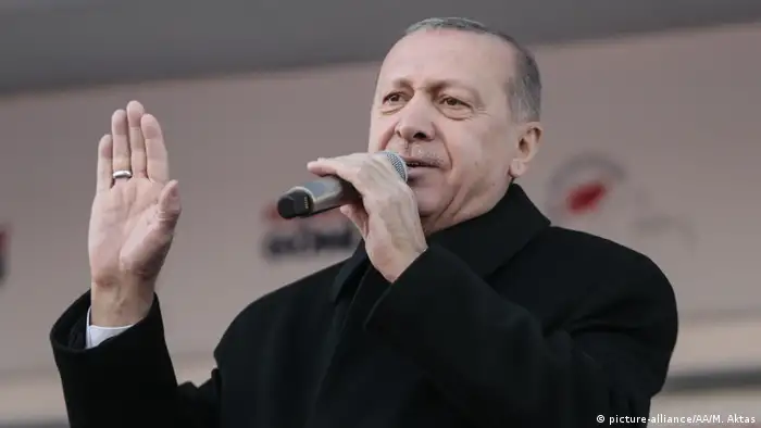 Recep Tayyip Erdogan speaking with a microphone