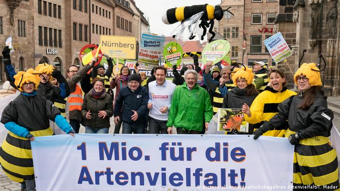 'Save the bees' activists hold signs (picture-alliance/dpa/Volksbegehren Artenvielfalt/T. Mader)