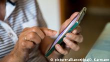 20.06.2017, Bayern, Kitzingen: Eine Seniorin bedient ein Mobiltelefon (Smartphone). Foto: Daniel Karmann/dpa | Verwendung weltweit