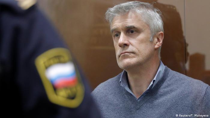 Michael Calvey behind a Russian officer after his arrest in February 2019