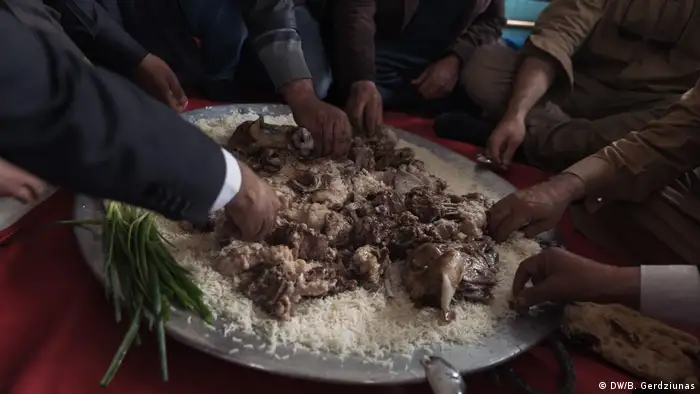 A group of men eating lamb and rice (DW/B. Gerdziunas)