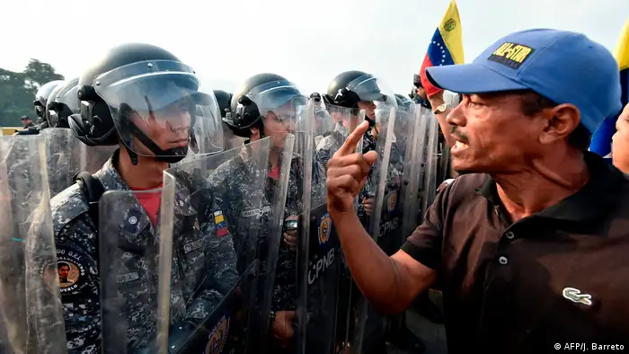 Один из демонстрантов спорит с венесуэльскими военными