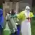 Helfer in einem Ebola-Behandlungszentrum desinfizieren einen Kollegen (im September)