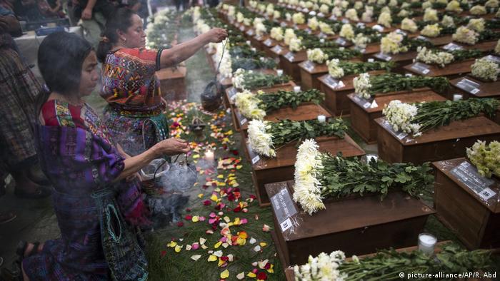 Foto de personas indígenas que rinden tributo a restos de víctimas del conflicto armado en Guatemala