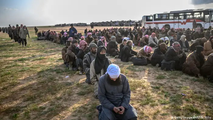Men suspected of being Islamic State (IS) fighters wait to be searched by members of the Kurdish-led Syrian Democratic Forces (SDF) after leaving the IS group's last holdout of Baghouz, in Syria's northern Deir Ezzor province on February 22, 2019