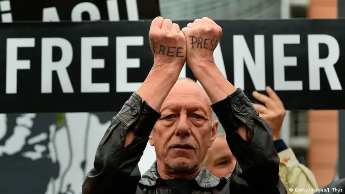 A man with the words 'free press' written on the backs of his hands protests alongside Amnesty International activists and partners outside the European Council building where EU diplomatic chief will meet with the Turkish foreign minister at the EU headquarters in Brussels on July 25, 2017.