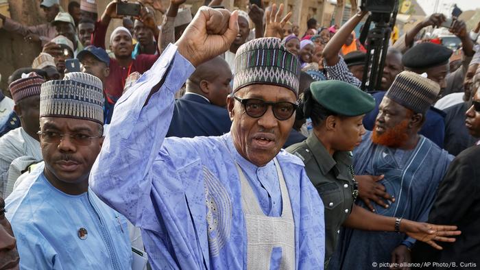 Nigeria's President Muhammadu Buhari gestures to supporters after casting his vote in his hometown of Daura in 2019