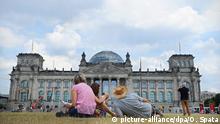 Menschen liegen und stehen am 25.07.2013 auf einer Wiese vor dem Reichstag in Berlin und genießen das Sommerwetter und den Ausblick. Foto: Ole Spata/dpa +++(c) dpa - Bildfunk+++ | Verwendung weltweit