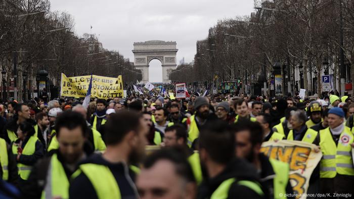 Yellow vest protests in Paris: Masses of people wearing yellow vests in the streets of Paris in front of the Arc de Triomphe.