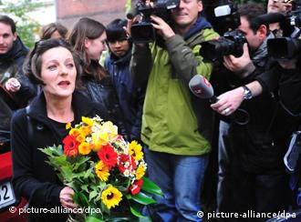 Herta Müller (l), verlässt mit einem Blumenstrauss in der Hand in Berlin ihre Wohnung und wird von Fotografen umringt (Foto: dpa)