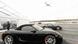 Two parked Porsches with a plane landing in the background Two parked Porsches with a plane landing in the background