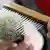 A badger-hair shaving brush being combed carefully