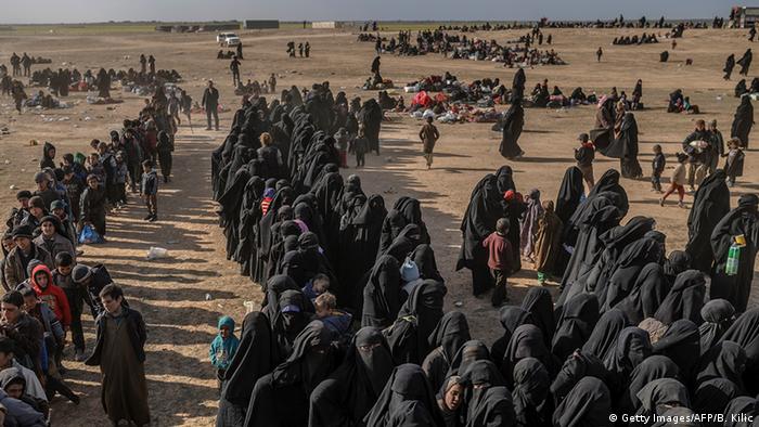 Civilians evacuated from the 'Islamic State' group's holdout of Baghouz wait at a screening area held by the Syrian Democratic Forces