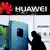 A woman walks past a Huawei store